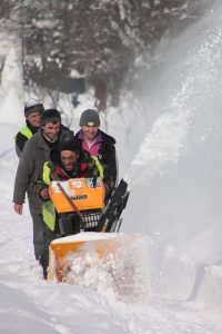 men outside using a snowblower 